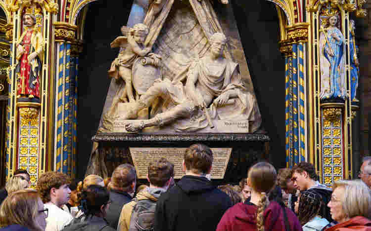 Photograph of group of people looking at one memorial within Westminster Abbey