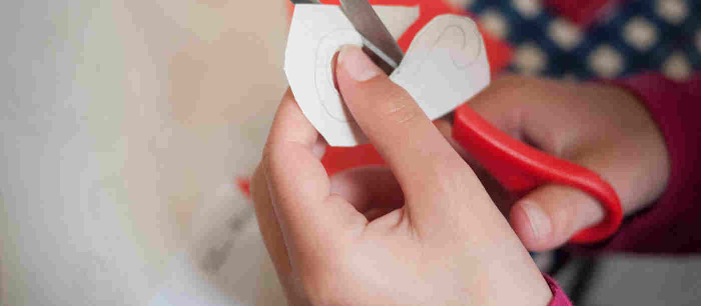 Close-up photograph of a child cutting out a shape, representing the craft activities within the A to Z of Westminster Abbey