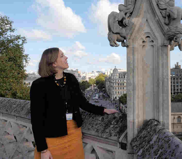 Photograph of woman standing on the roof of Westminster Abbey looking towards the Houses of Parliament