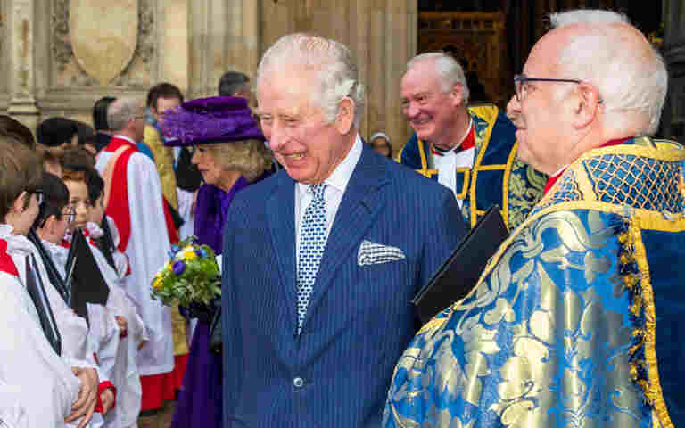 King Charles III talking to choir boys outside the Abbey. He is standing next to the Dean.