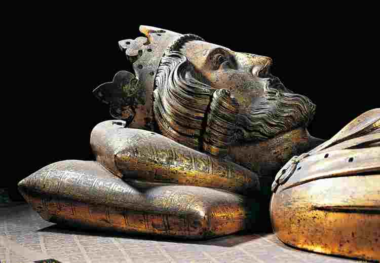 Side view of Henry III's bronze effigy, his head resting on a pillow
