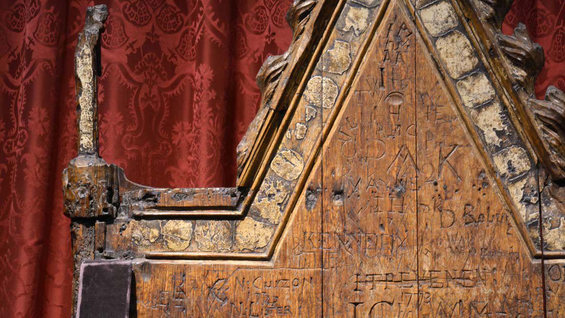 Detail of the Coronation Chair, showing graffiti scratched into the wooden back of the chair