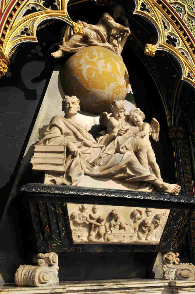 Isaac Newton memorial, showing marble carving of Newton reclining on a pile of books next to two angels, with a yellow and white globe above them