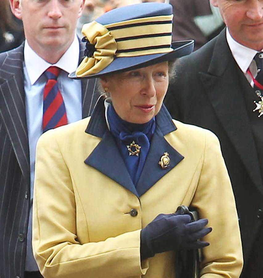 Princess Anne, The Princess Royal, wearing a yellow and blue hat and coat and blue gloves