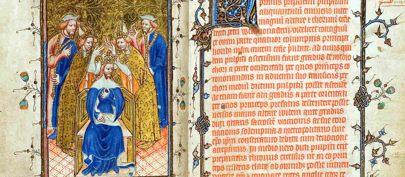 Photograph of two pages of the Liber Regalis, the guide to the coronations, on display at Westminster Abbey. The left illumination shows a king being crowned, surrounded by members of the clergy, while the right side shows a page of medieval Latin writing with an illustrative border.