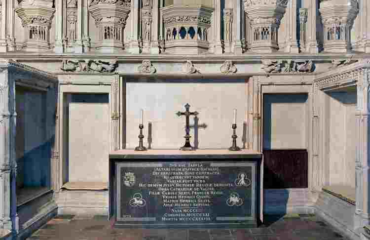 Altar with two candles and a crucifix on top marking the burial place of Catherine de Valois