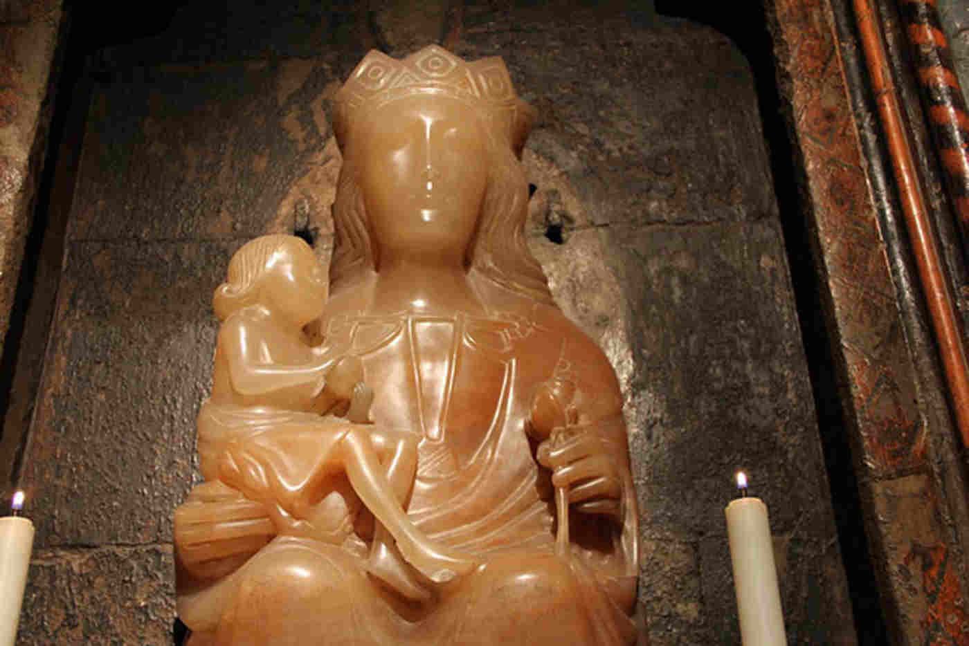 Statue of Our Lady of Pew with a small candle on either side