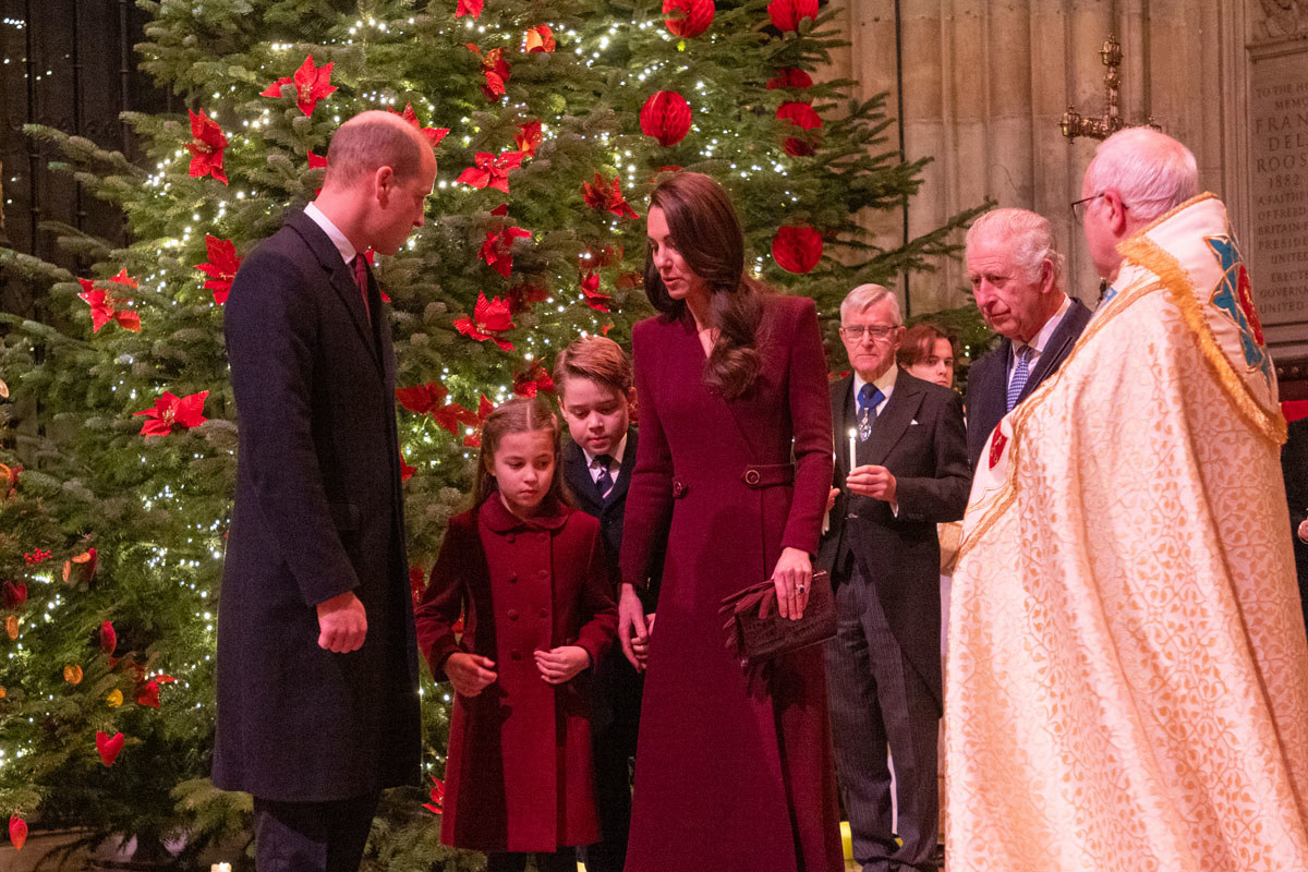 Prince William, Kate Middleton, Prince George, Princess Charlotte, King Charles and the Dean of Westminster. A Christmas tree can be seen in the background