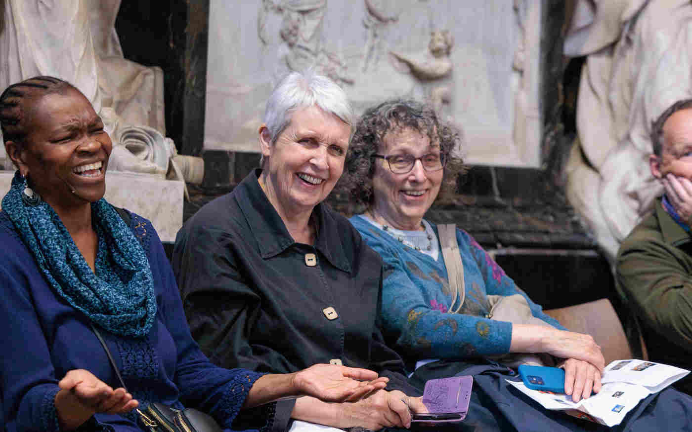 Photograph of seated members of the public laughing within Poets' Corner in Westminster Abbey