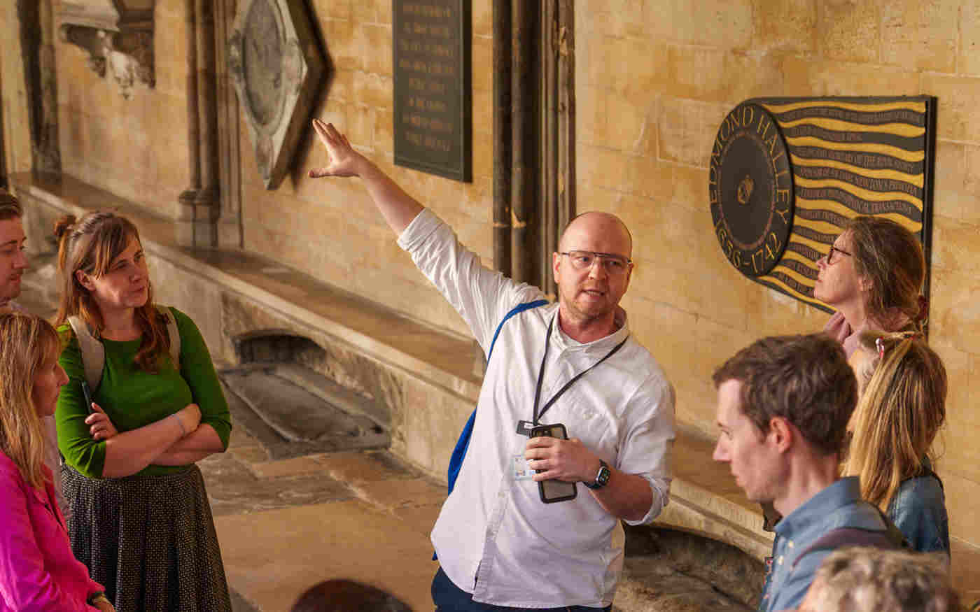 Photograph of adult leading a tour group in the cloisters of Westminster Abbey