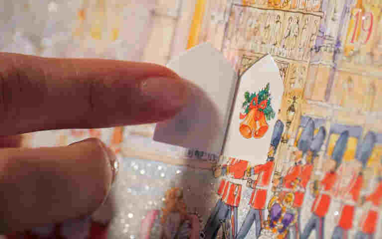 Close-up photograph of a finger opening a door on an advent calendar
