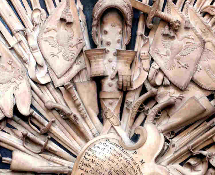 Close-up photograph of a memorial to the Killigrew family within Westminster Abbey, a stone tablet showing weapons