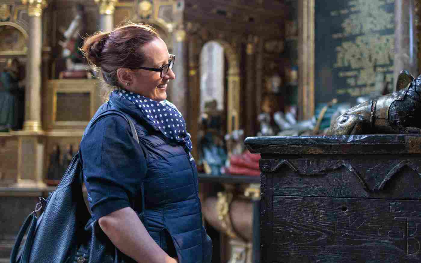 Photograph of visitor looking closely at a memorial in a chapel within Westminster Abbey